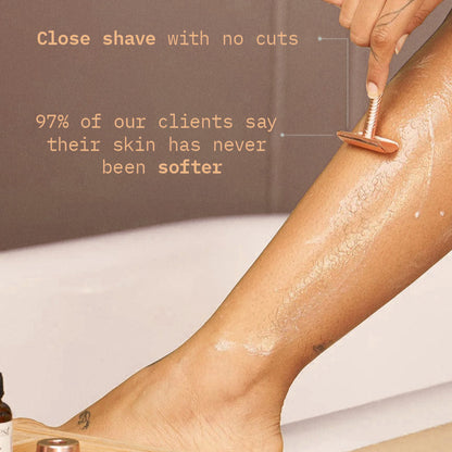 Person shaving leg with a rose gold razor, showing smooth skin.
